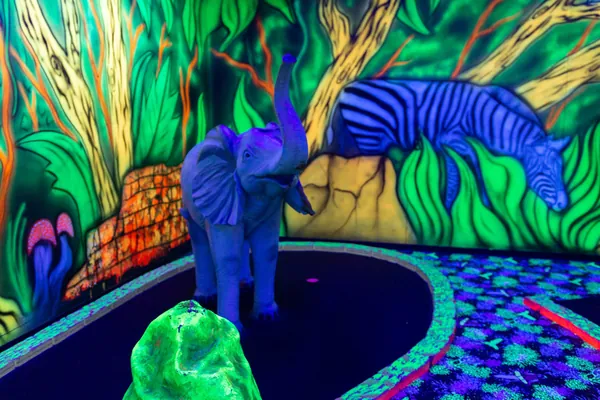 Elefant und Zebra in Neonfarben im Dschungelbereich der Anlage